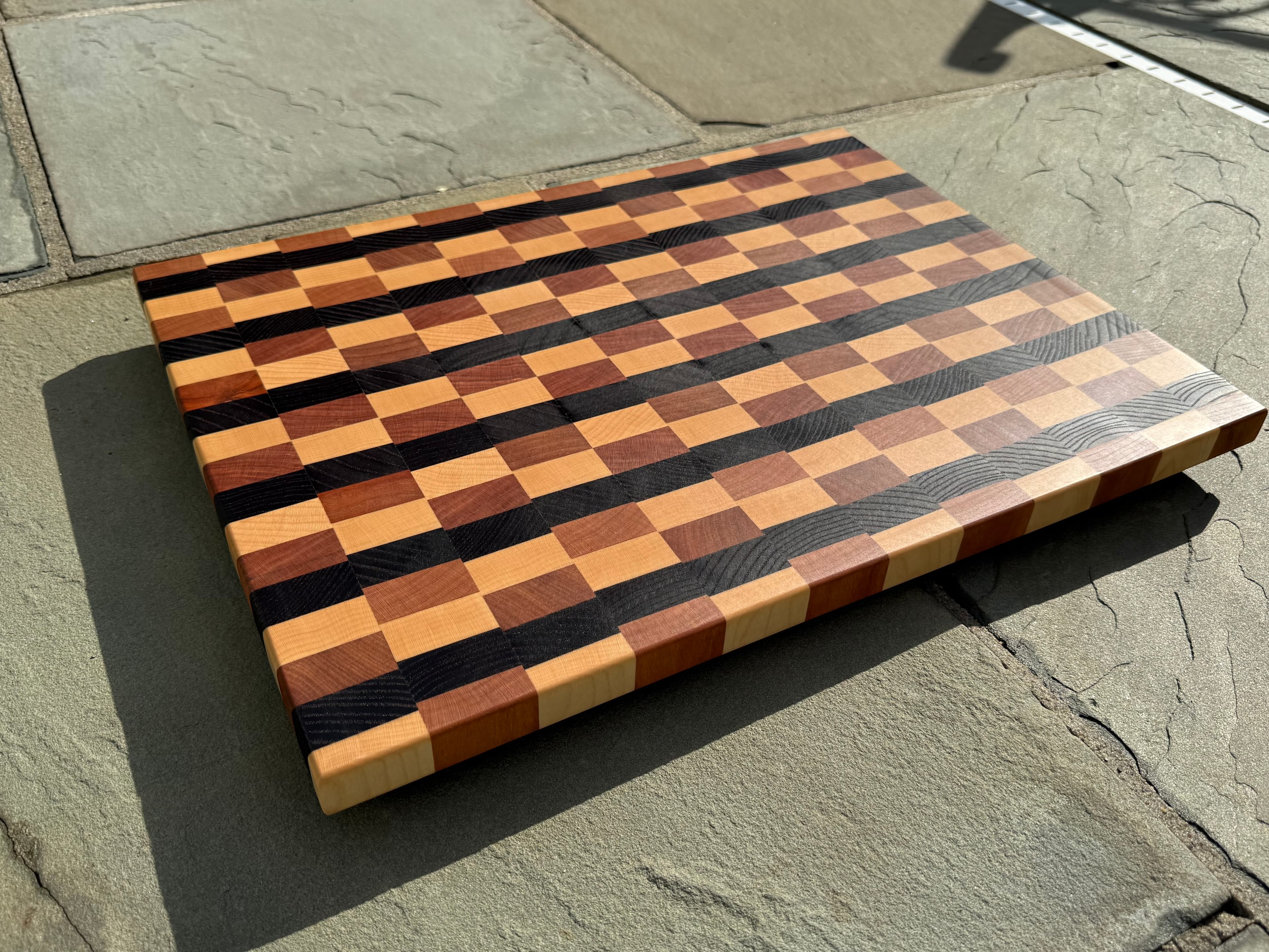 Handmade cutting board with alternating dark and light end-grain patterns