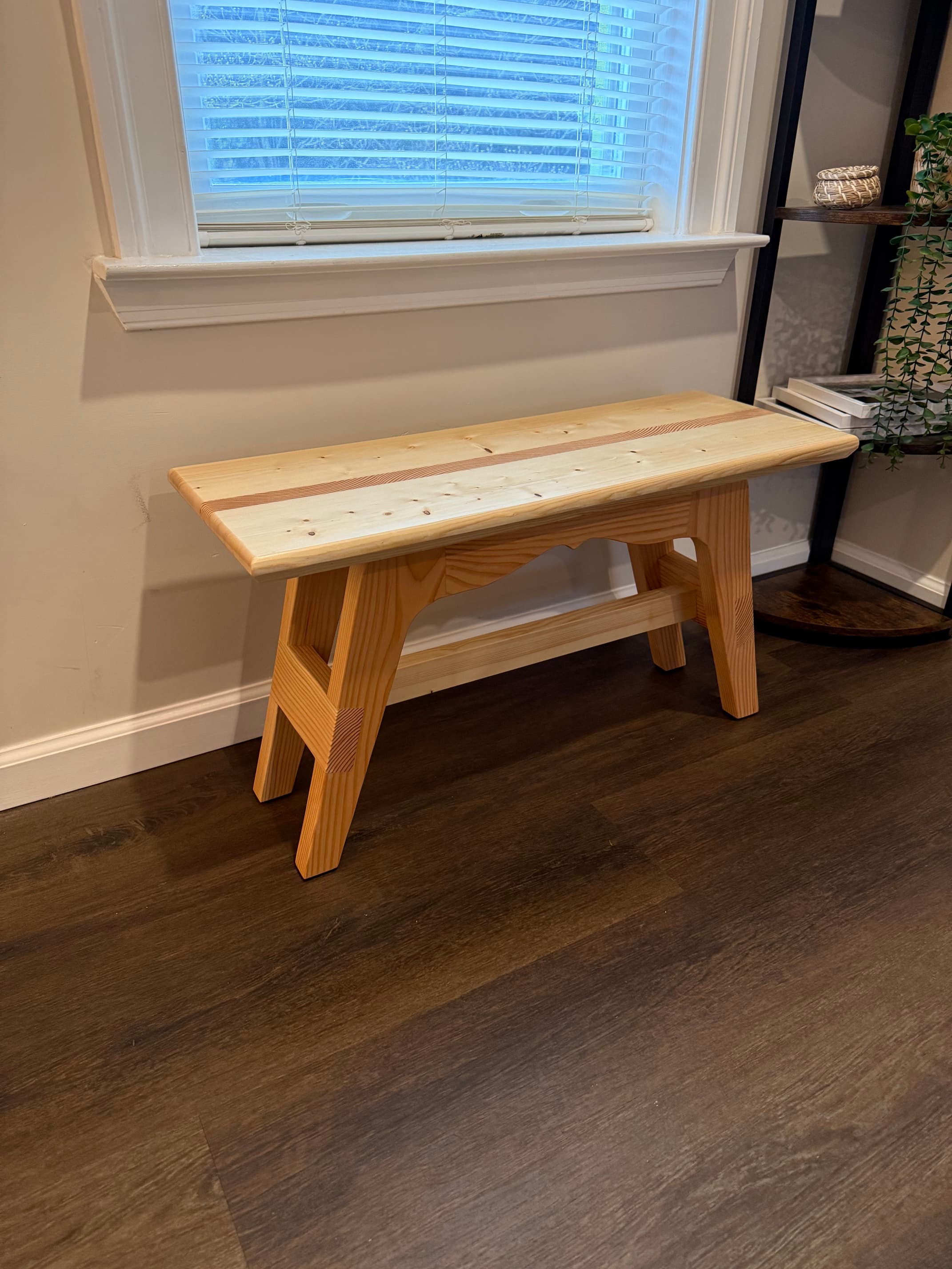 Handmade wooden foyer bench beneath a window
